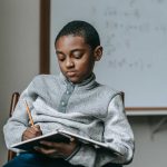 african boy writing in a book